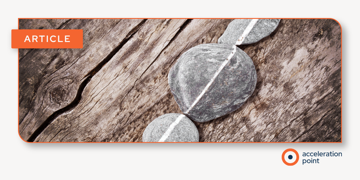 Stones balanced along one line on weathered wood, suggesting a unified KOL engagement strategy across co-commercialization partners.