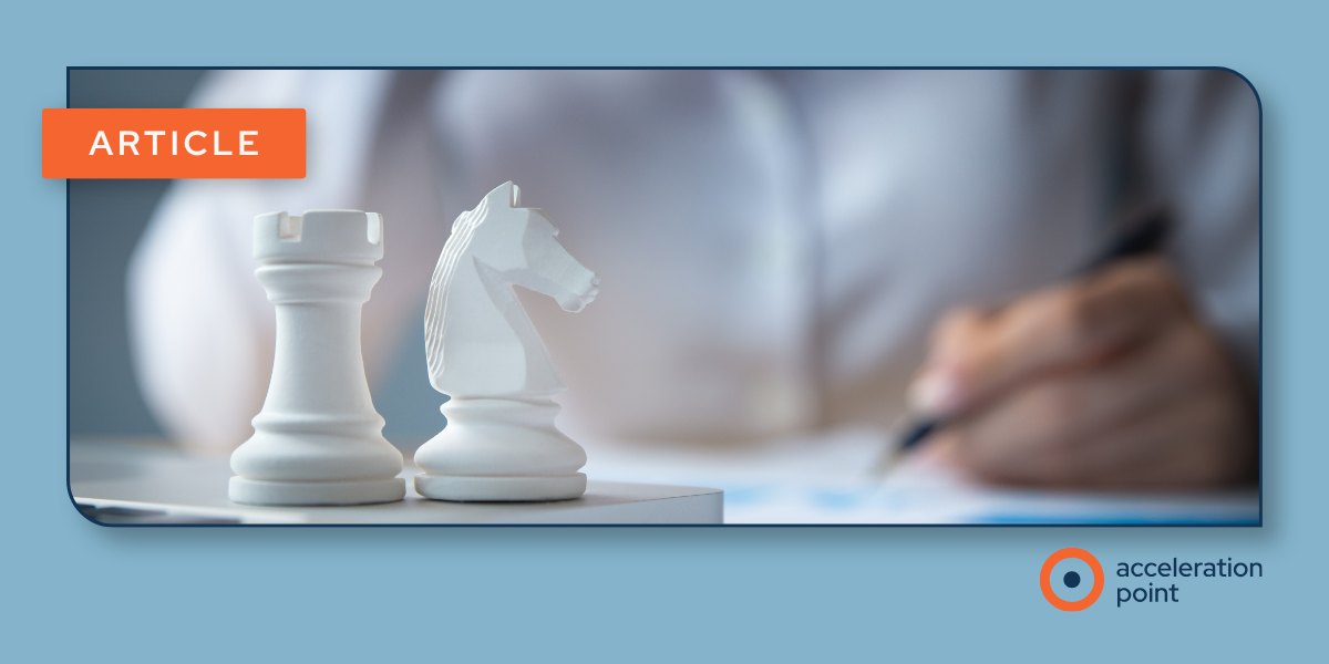 Chess pieces beside a person writing represent strategic planning and coordinated decision-making in KOL co-commercialization engagement.
