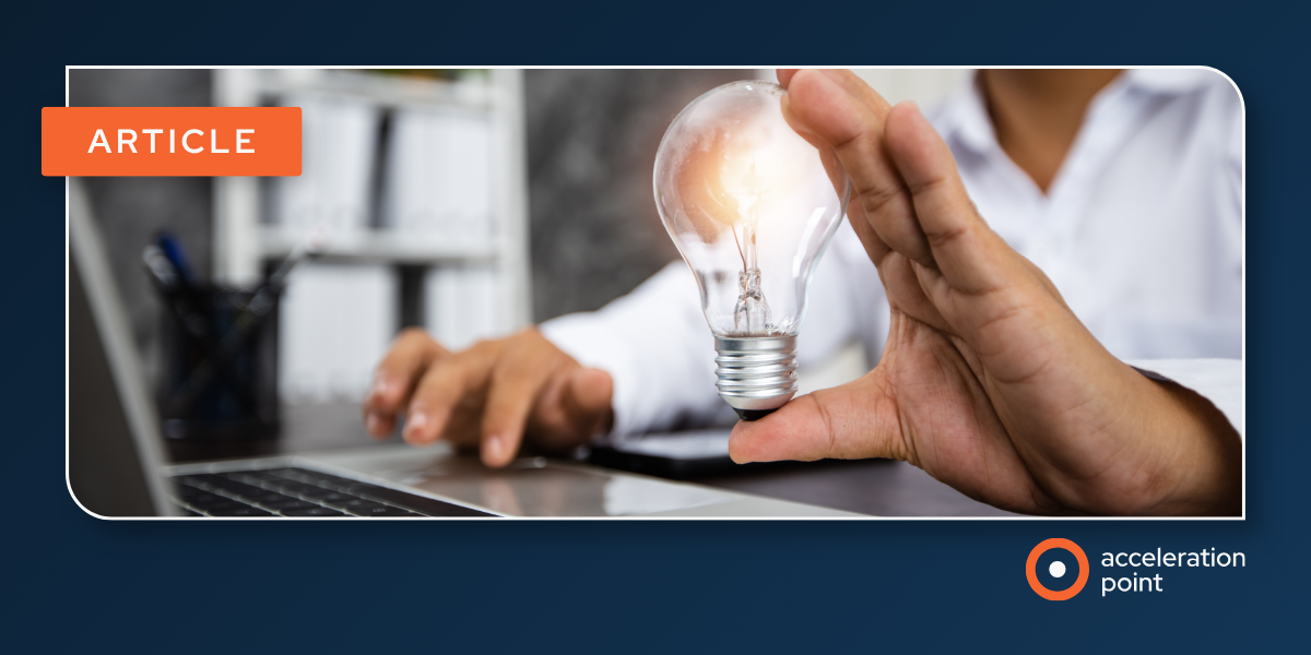 A hand holds a glowing lightbulb beside a laptop, representing actionable medical insights Medical Affairs teams route to MSLs on demand.