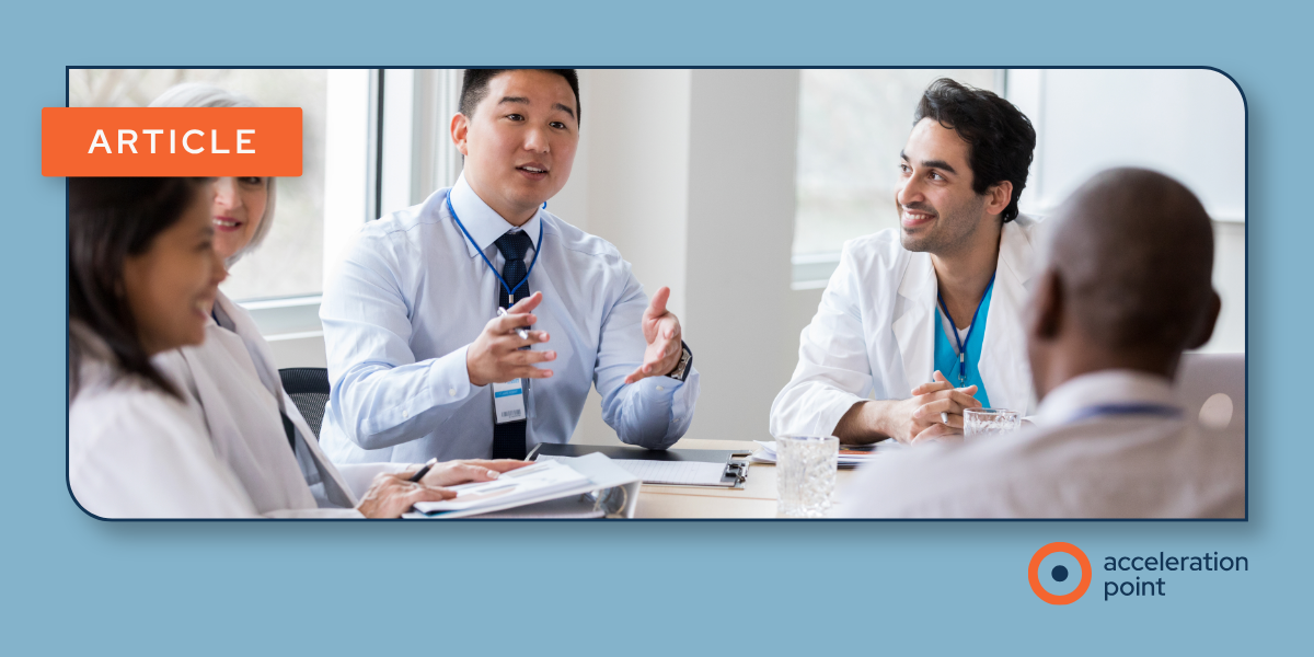 Medical professionals in lab coats talk across a table, illustrating the peer-to-peer scientific exchange central to the MSL role.